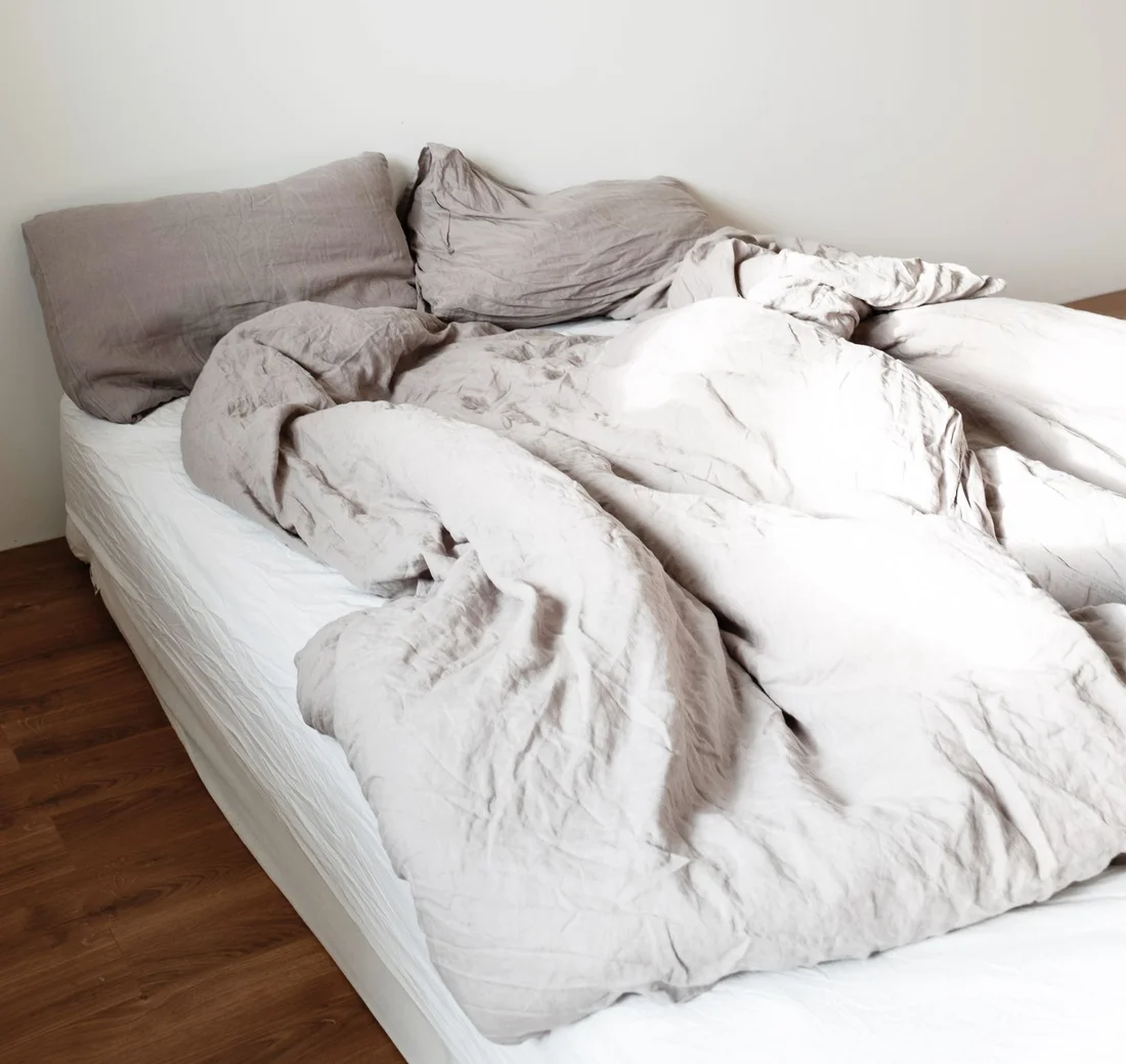 Soft neutral bedding in a sunlit bedroom