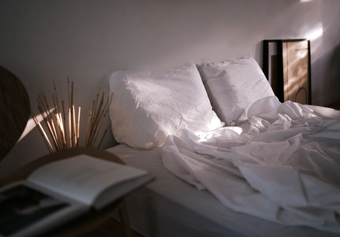 White pillows and rumpled bedding in natural window light
